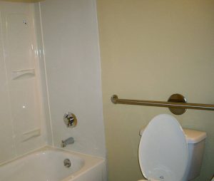 bathroom with grab bar handle for safety near toilet